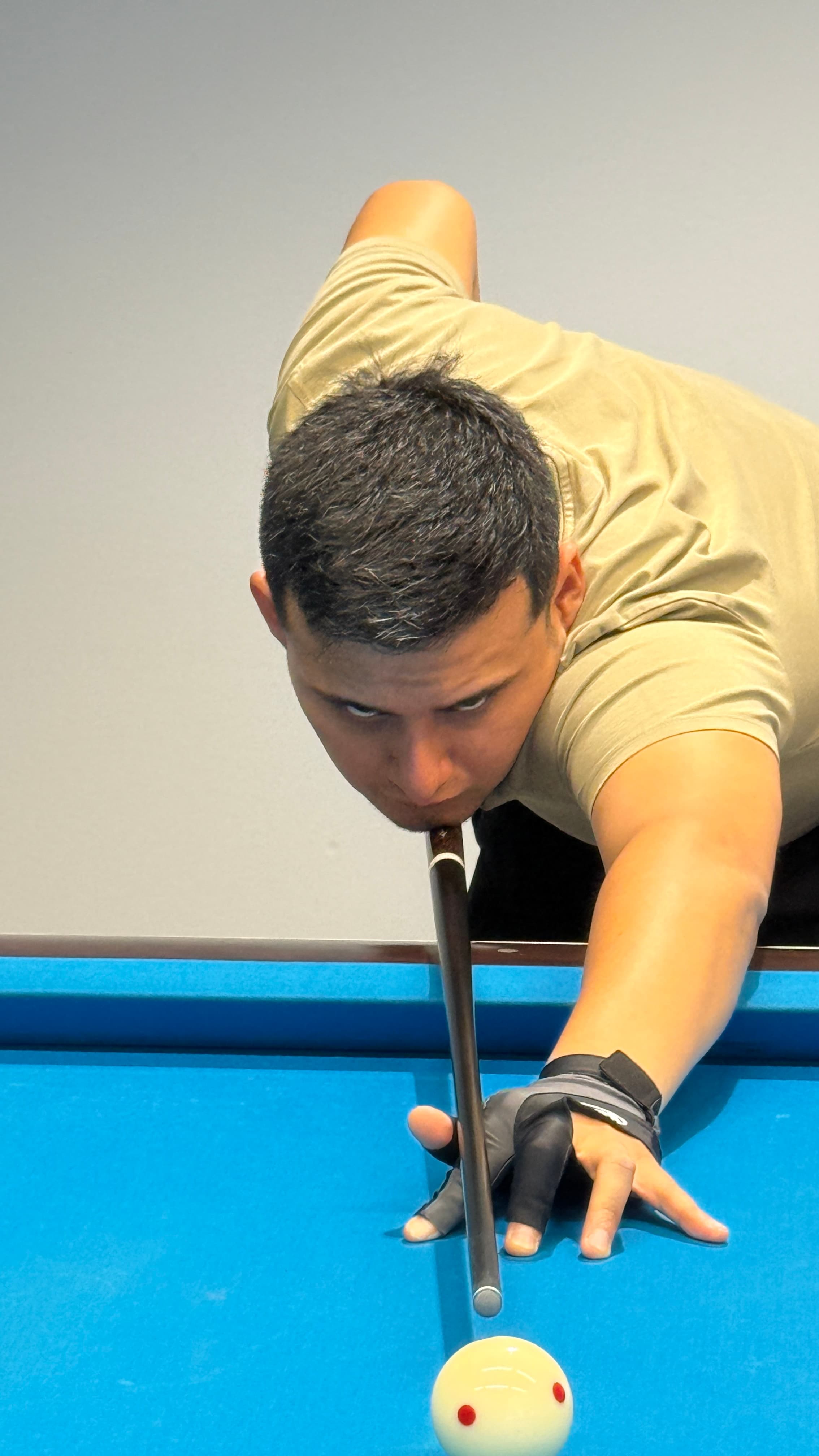 A player takes aim at a pool table in an urban indoor environment.