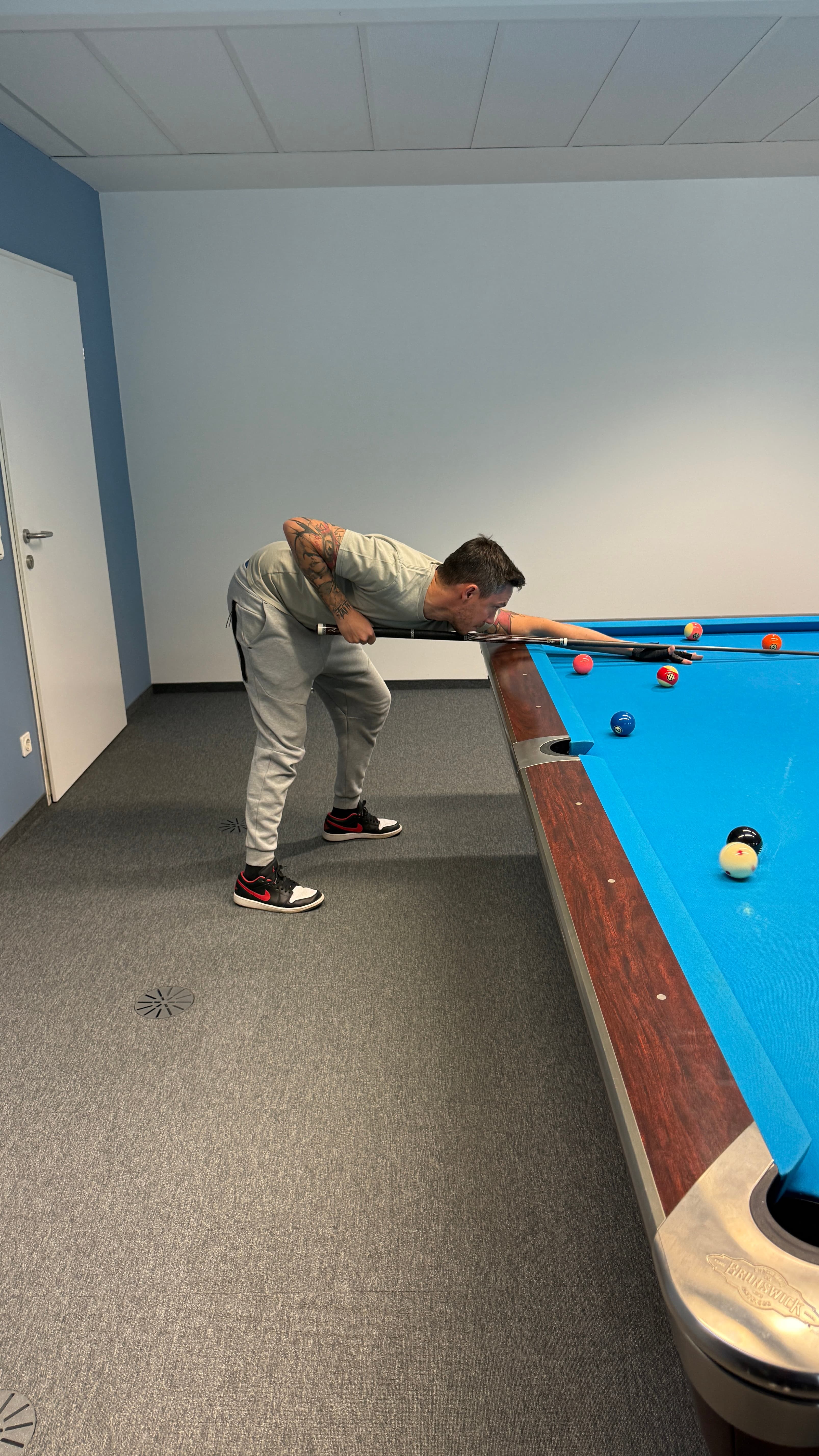 Two people play billiards in a stylish interior.